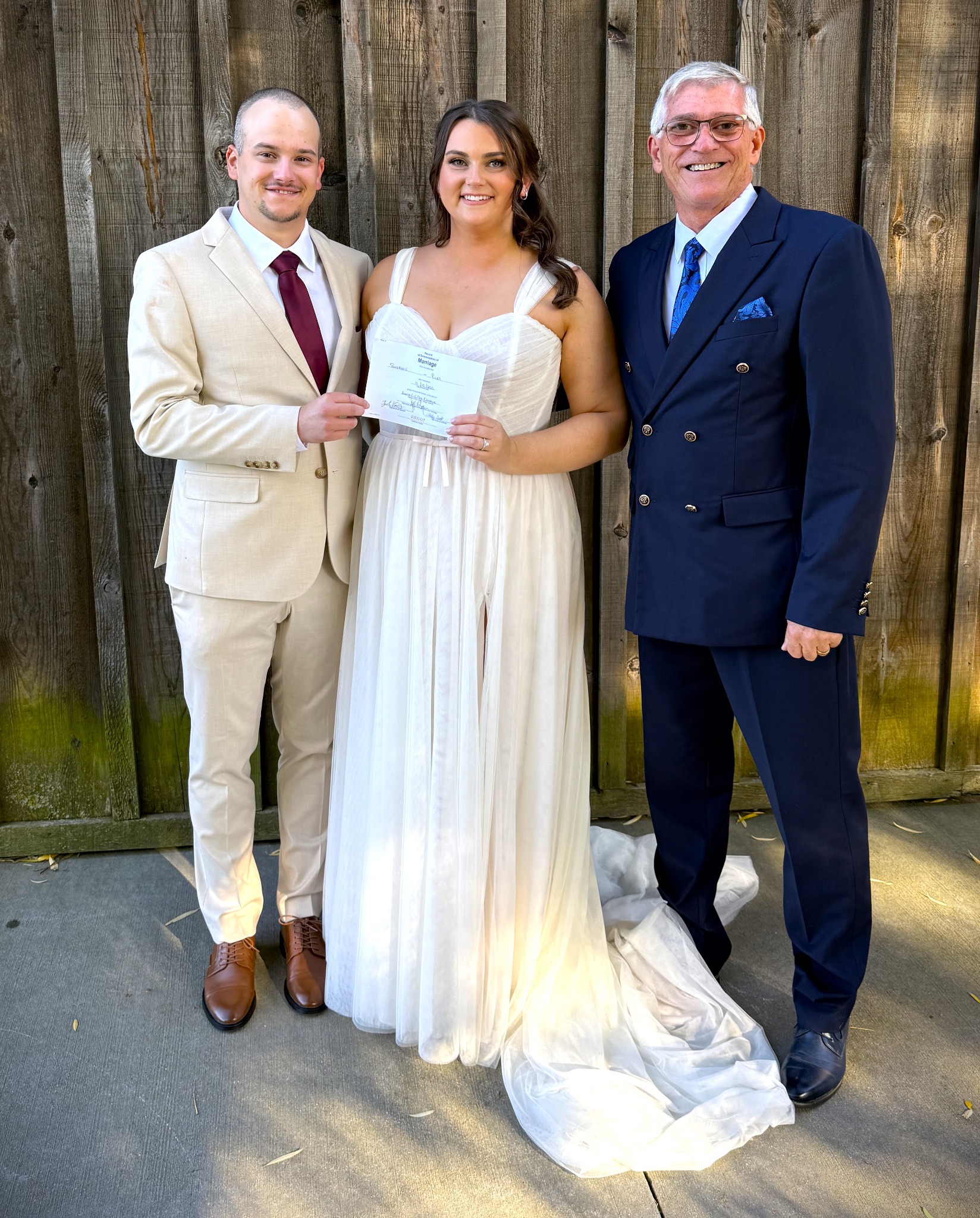 Jeff Sager with newlyweds holding their marriage certificate